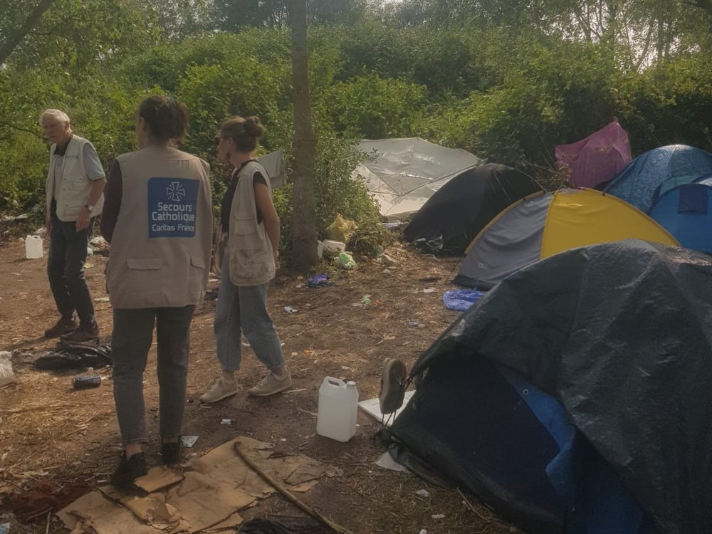 Bénévoles du Secours Catholique sur un campement de personnes exilées à Calais